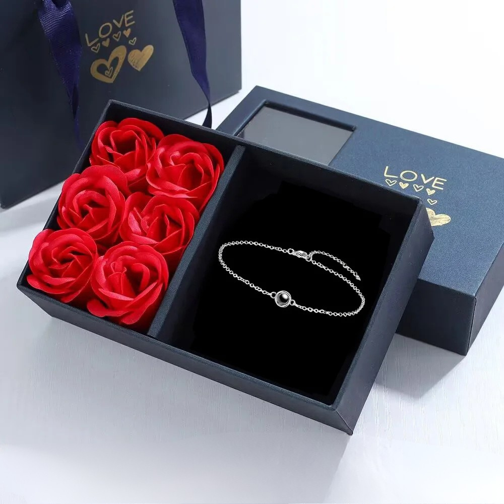 Coffret cadeau ouvert avec bracelet de projection photo personnalisé : un bijou unique avec une image cachée à regarder à l'intérieur.