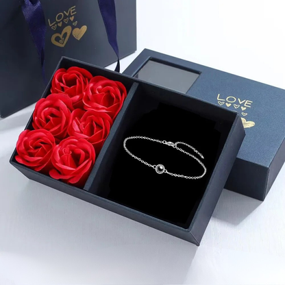 Coffret cadeau ouvert avec bracelet de projection photo personnalisé : un bijou unique avec une image cachée à regarder à l'intérieur.