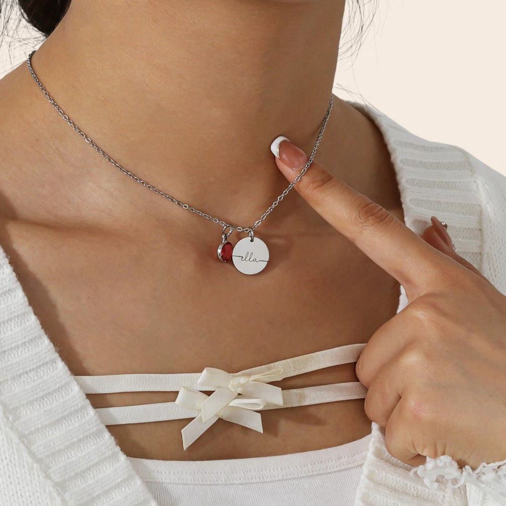 Collier médaillon personnalisé de couleur argent avec prénom gravé et pierre de naissance, porté autour du cou.